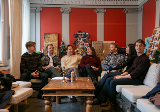 Gruppefoto av Akantus, jenter og gutter sitter i en sofa.
