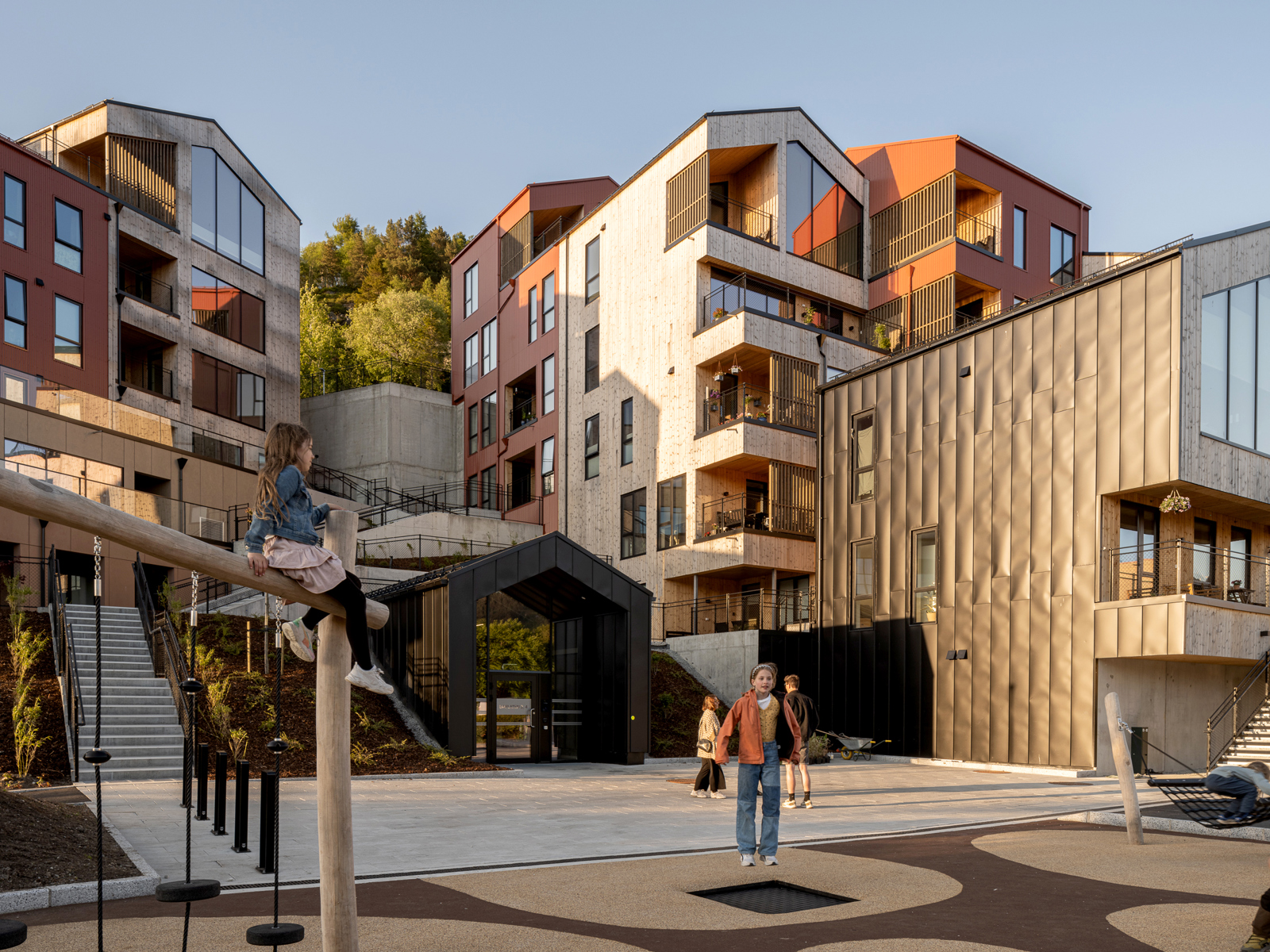 Bakgård i boligområde med mykt underlag ved lekeplass. Foto.