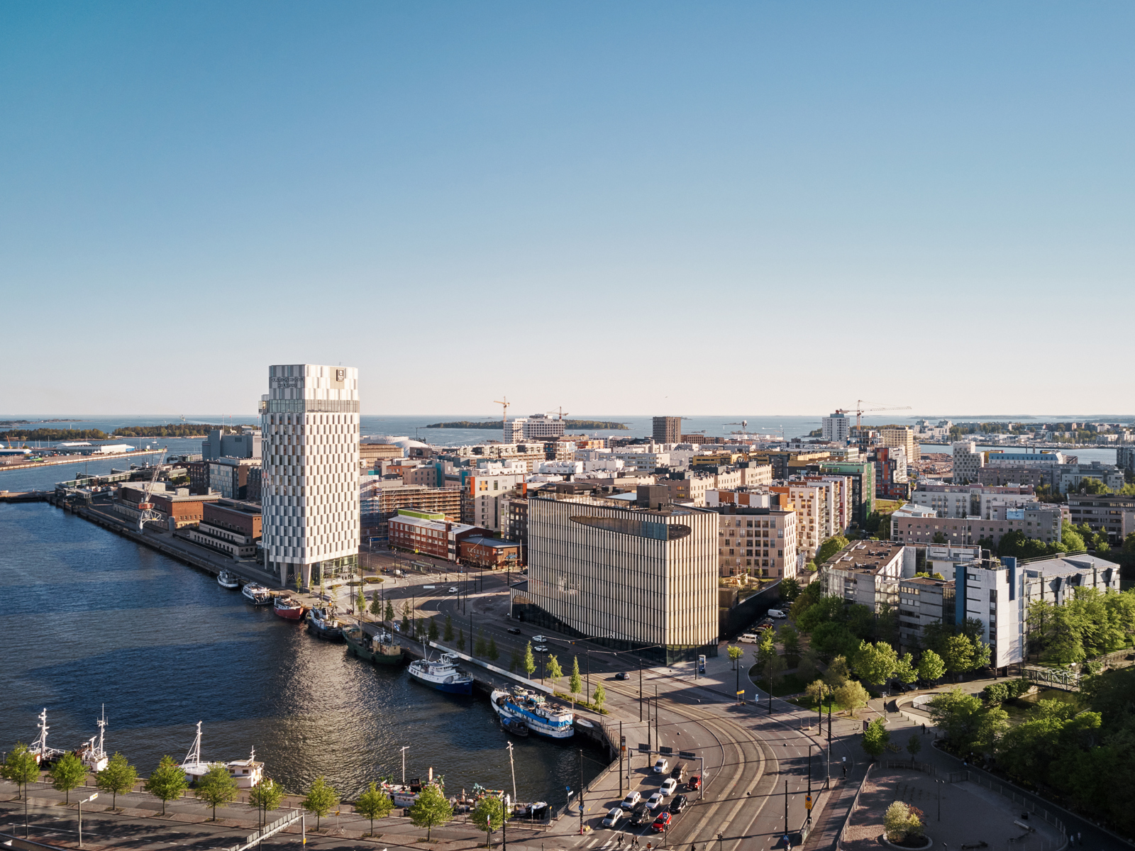 Oversiktbilde over Woodcity i Helsinki, bydel nær vann, vei og hav i forgrunnen. Foto.