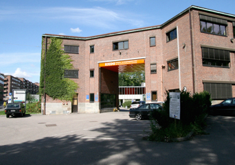Portalen inn til arkitektur og design-høgskolen i Oslo med parkeringsplassen i forgrunnen. Foto.