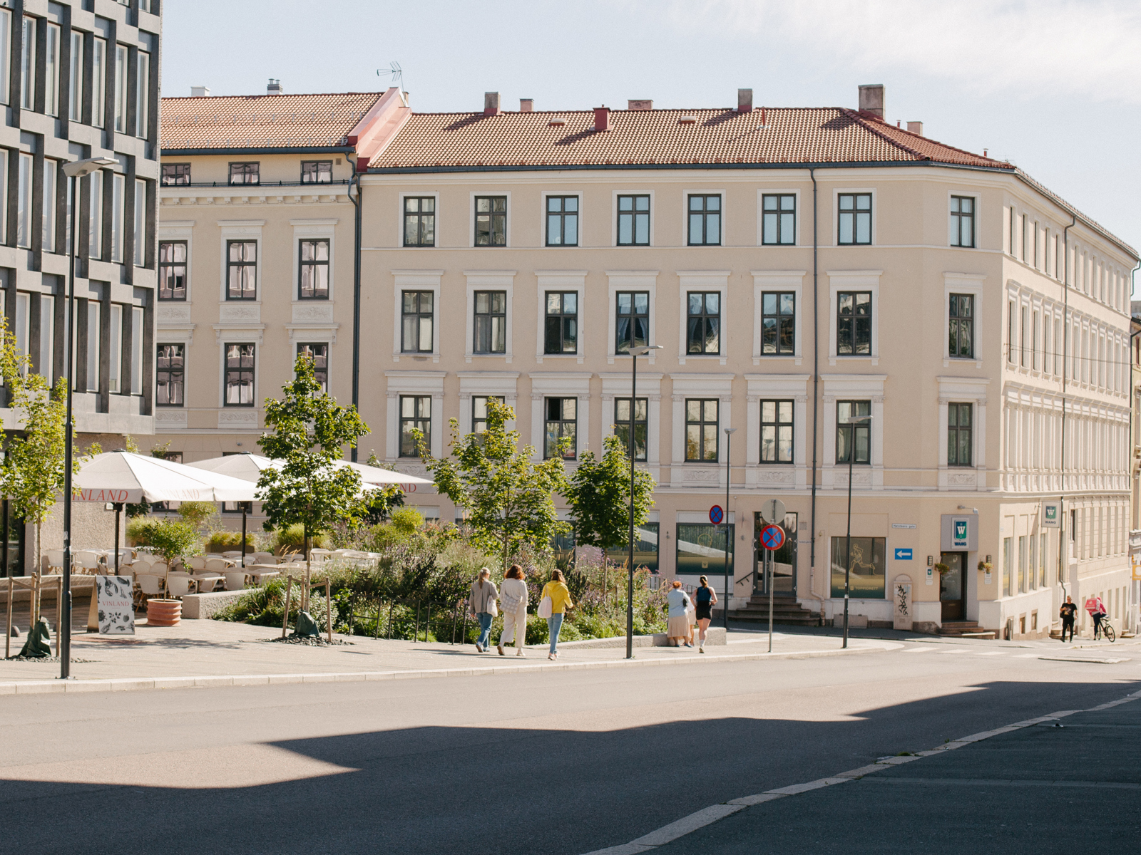 Foto av uteområdet langs ambassade, plantefelt, bygård i bakgrunn.