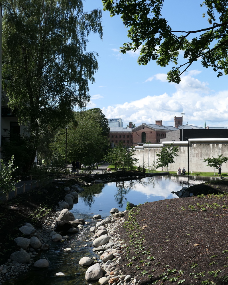 Bekk går ut til et liten dam, by kontekst. Foto.