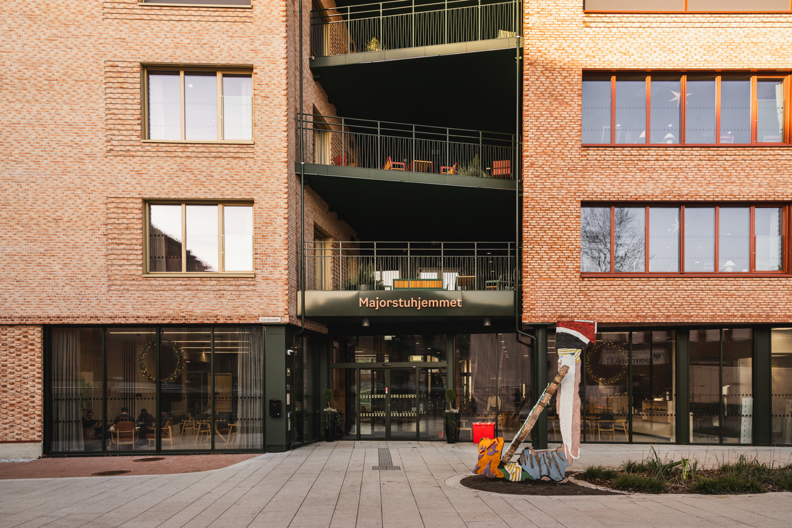 Foto av fasaden og inngangspartiet på Majorstuhjemmet, tegl og svarte metall detaljer.
