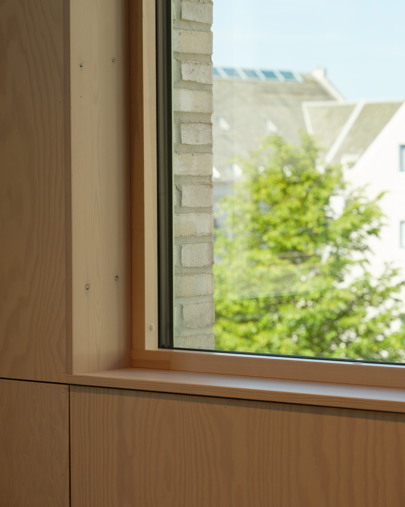 Interiør detalj foto av vinduskarm. Treverk på innsiden, tegl på utsiden.