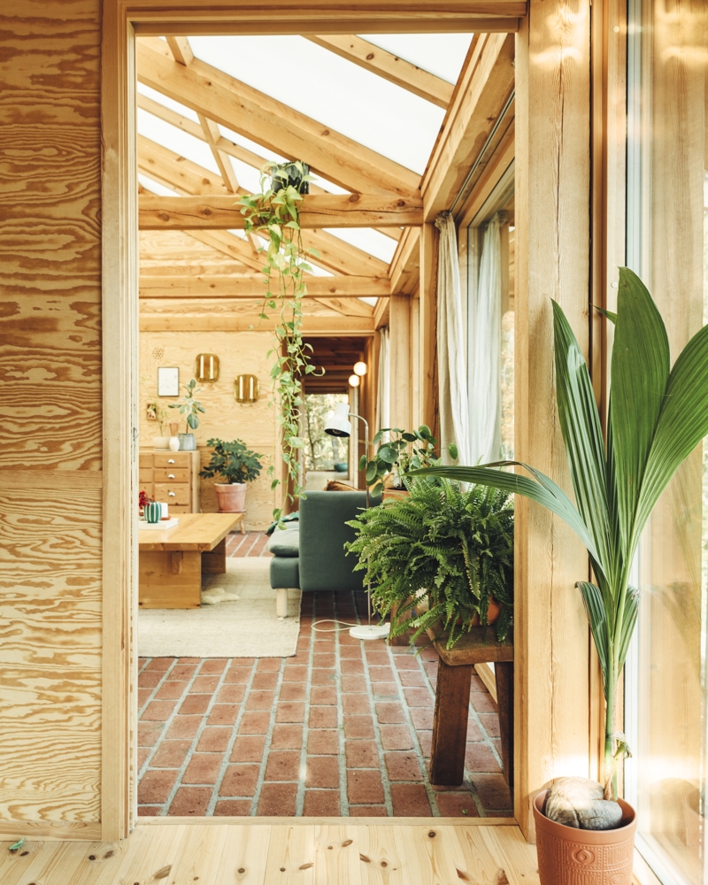 Interiør foto av stue gjennom døråpning, treverk, tegl gulv.