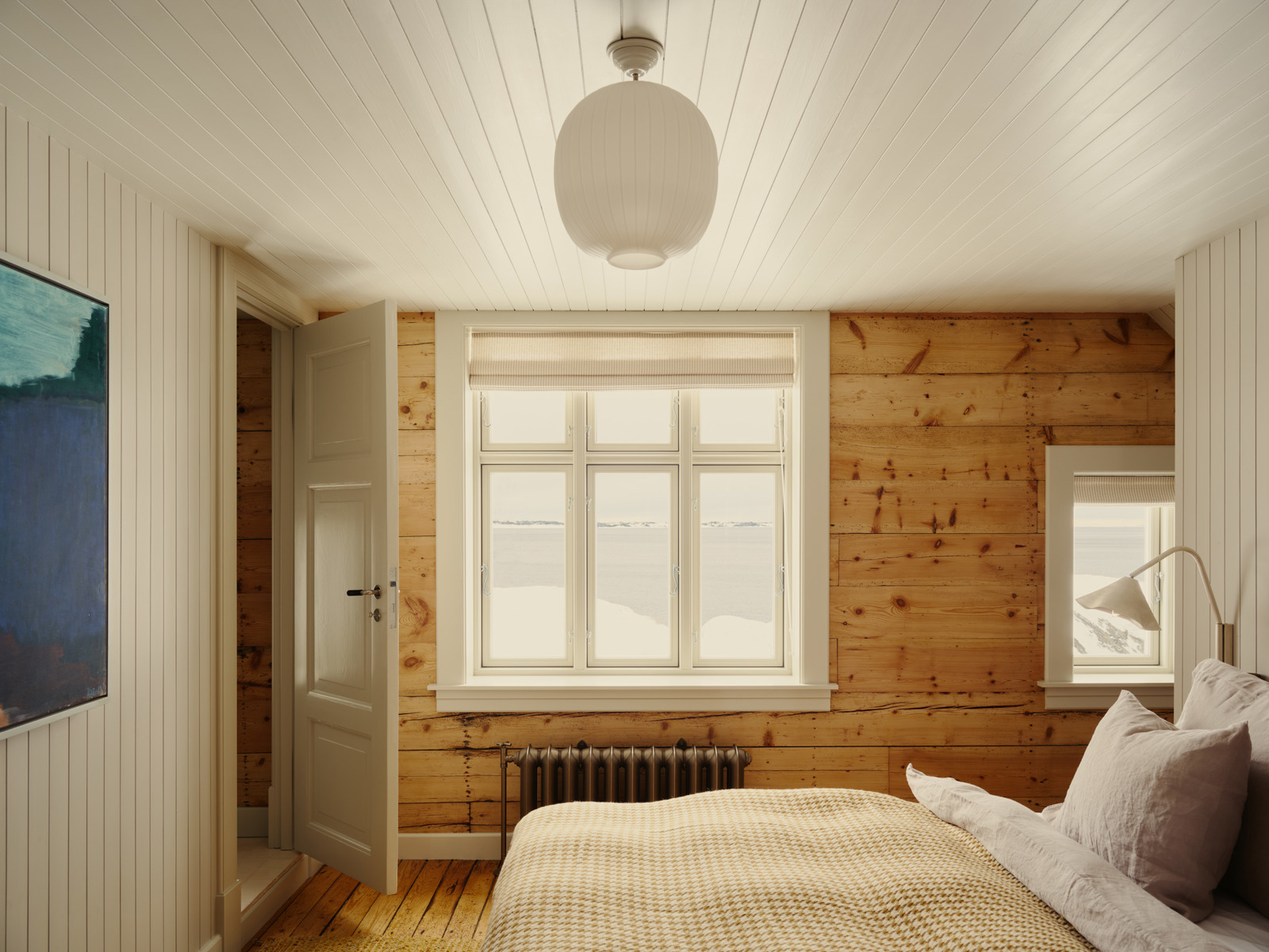 Interiør foto av et soverom, varmt treverk og lyse farger.