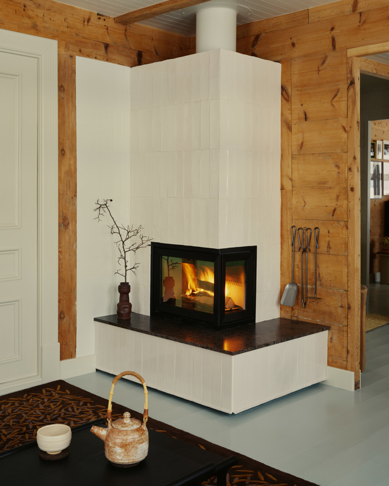 Interiør foto av en hvit peis i et hjørne.