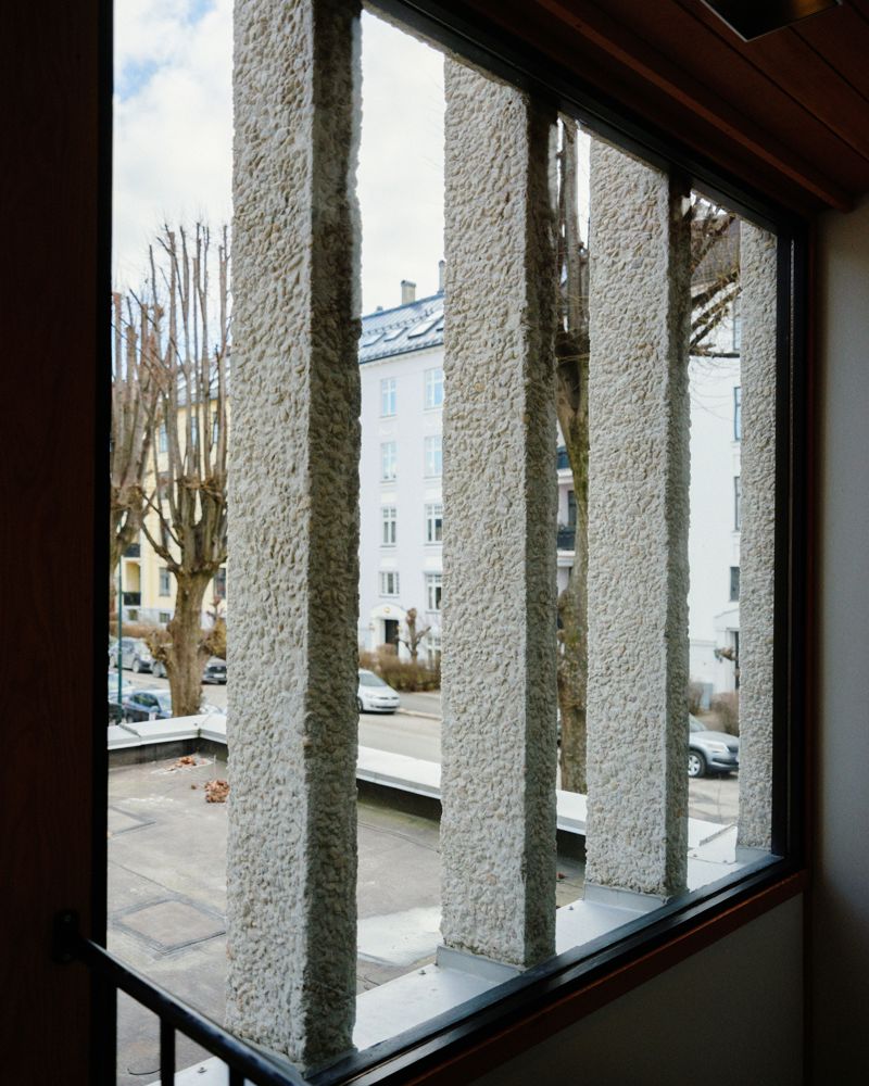 Foto av vindu med betong bjelker som går opp og forbi på utsiden. 
