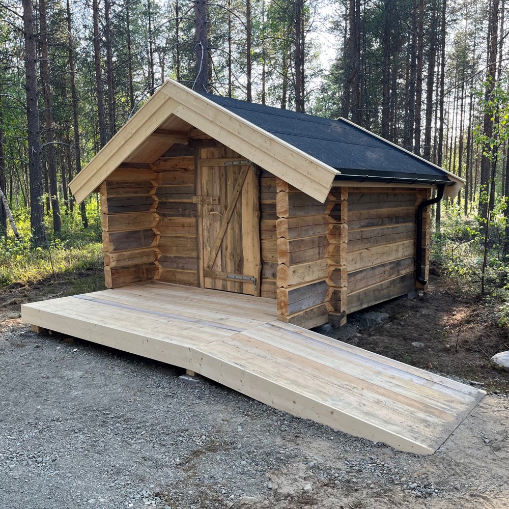 Foto av lite tømret hus med rampe opp til dør