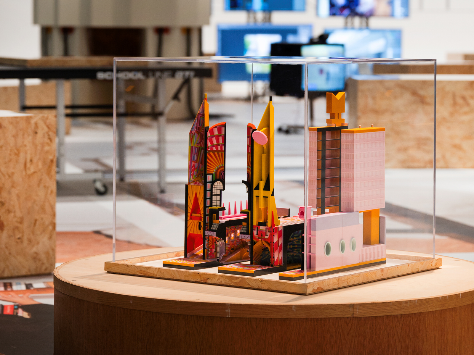 Foto av utstillings monter med fargerik arkitekturmodell inni.