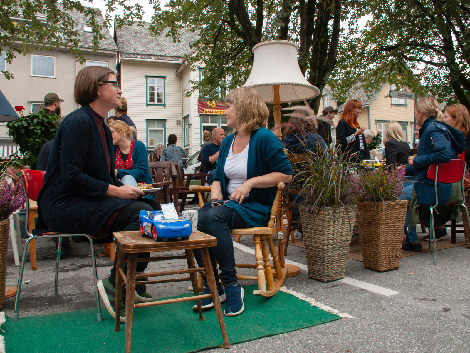 mennesker som sitter på stoler på et torg