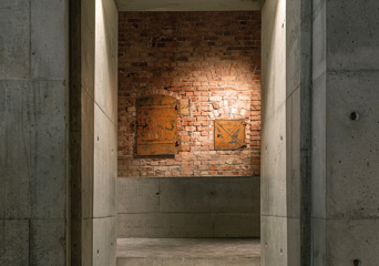 Interiør, betong og tegl, døråpning. Foto.