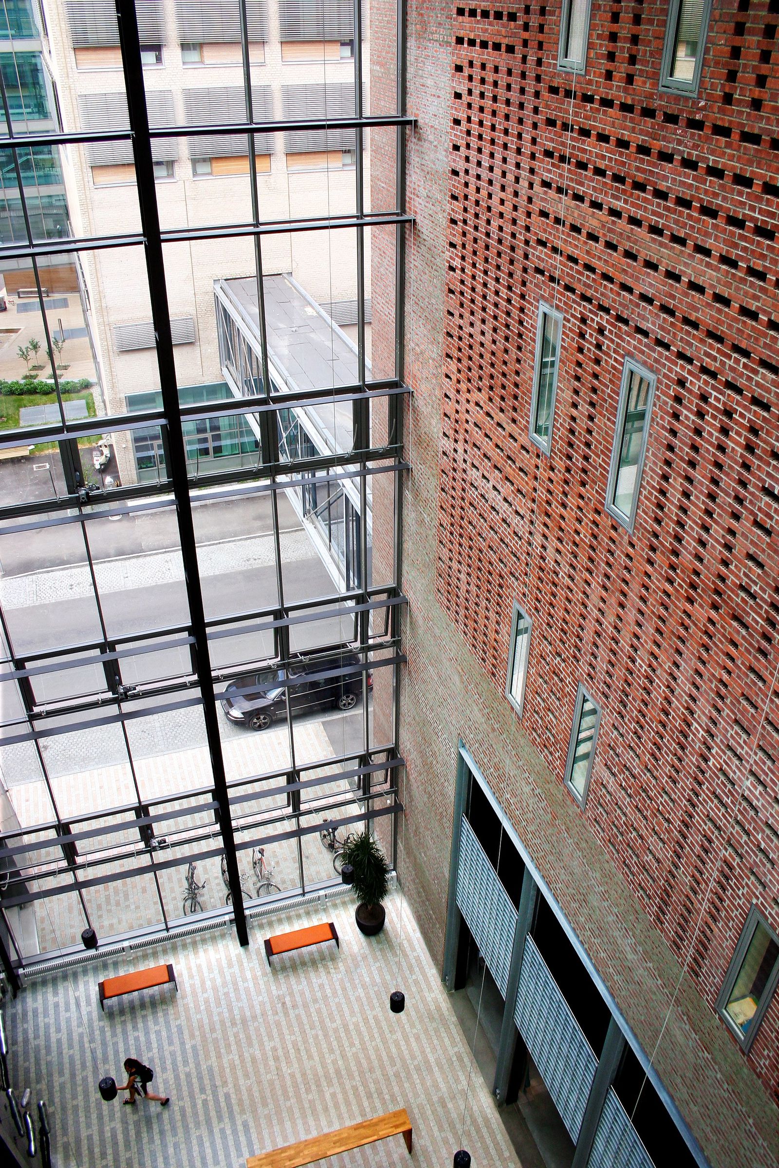 Foto ned i et høyt felles halvklimatisert rom med store glassflater mot gaten, og vegger i tegl.