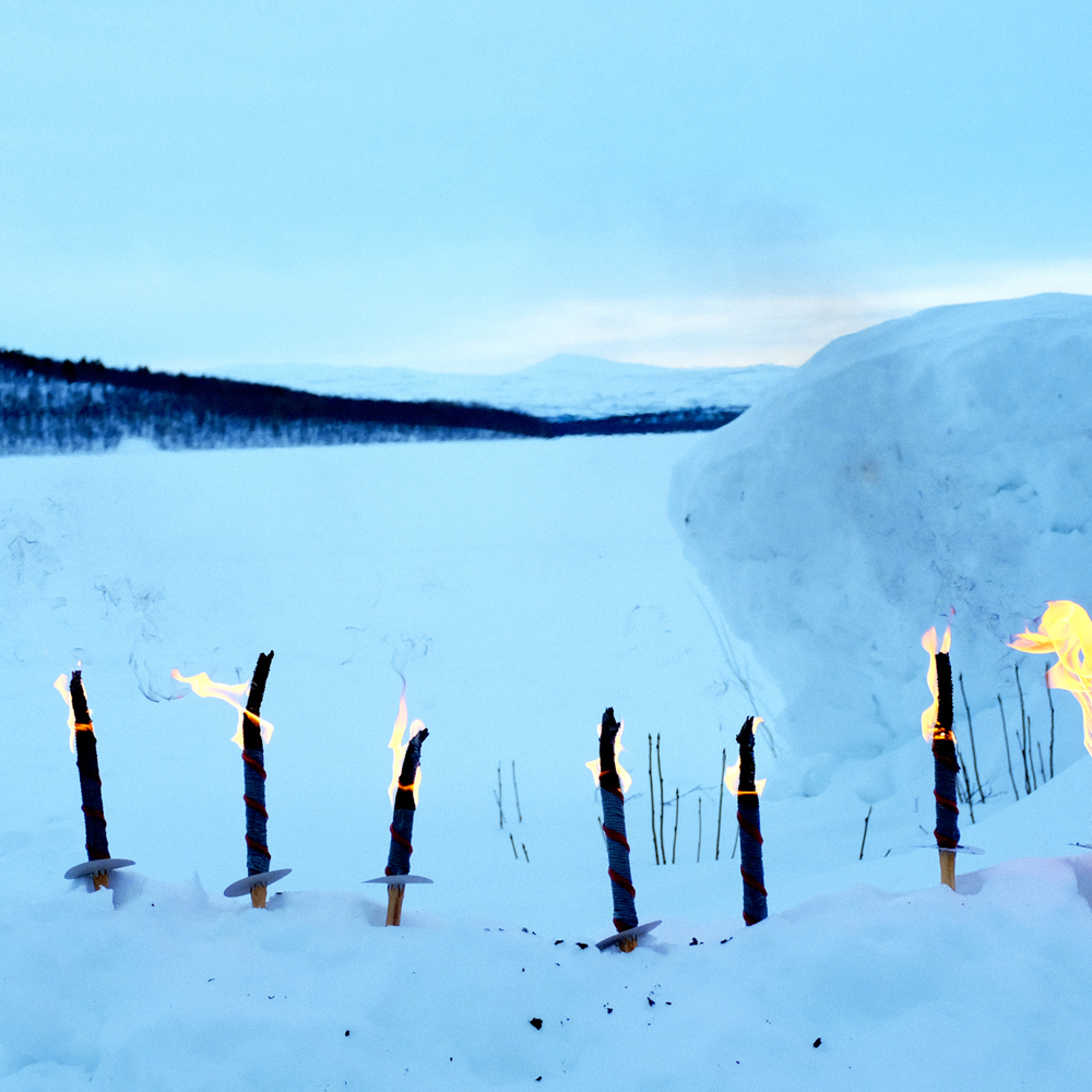 Påtente fakler i et vinterlandskap