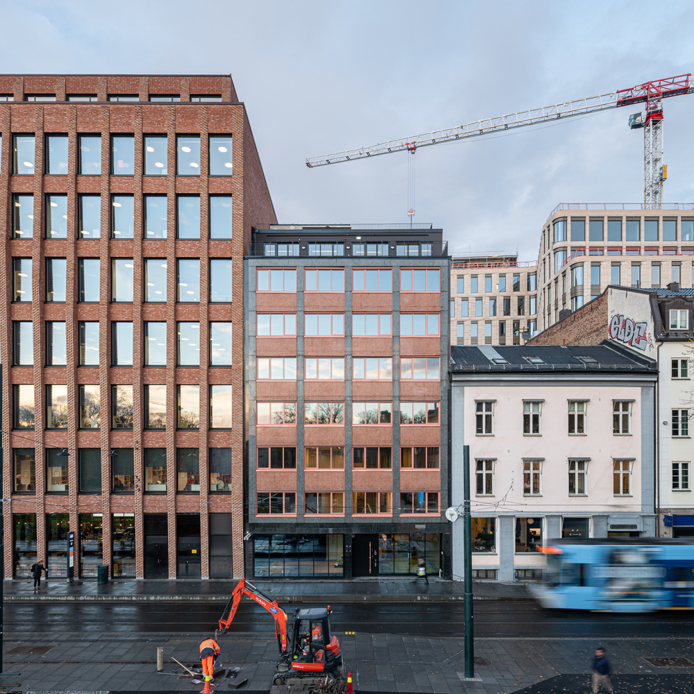 Foto av eksteriøret, streng rytmisk fasade av glass og tegl.