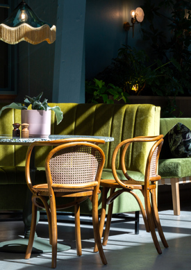 Sittegrupper, grønne sofaer med stoler i tre. Interiør. Foto.