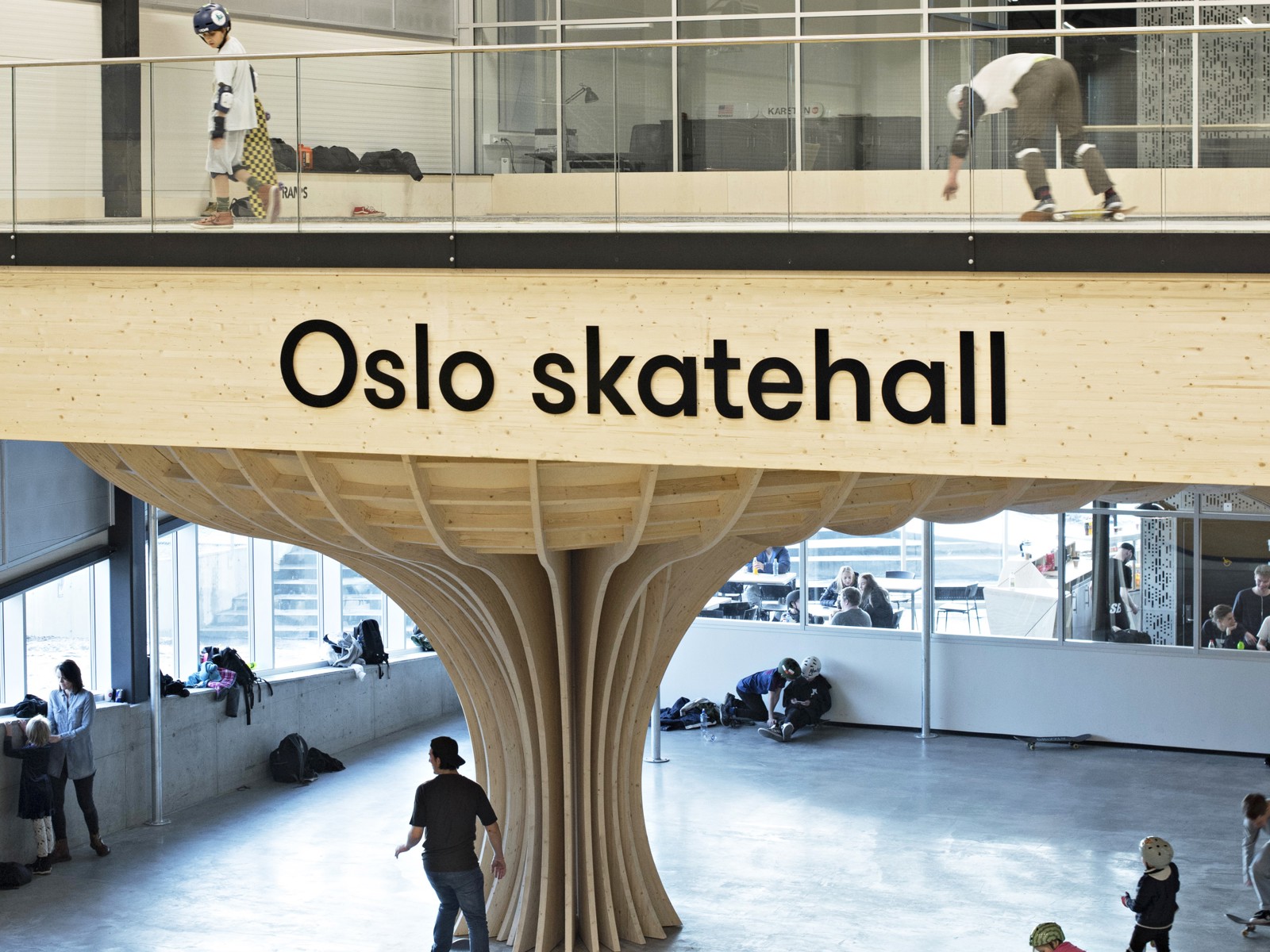 Interiør Oslo Skatehall, skilt, skaterampe, treverk, skater. Foto.