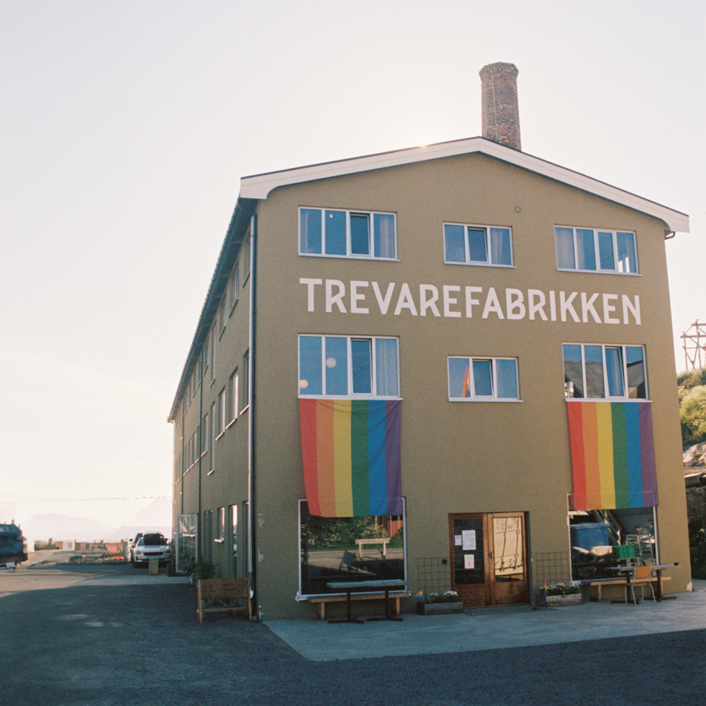 Foto av Trevarefabrikken med regnbue flagg hengende utenfor vinduene.