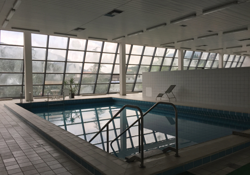 Badebasseng med vindu langs veggene. Foto. 