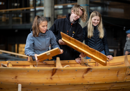 Tre båtbyggere over en trebåt