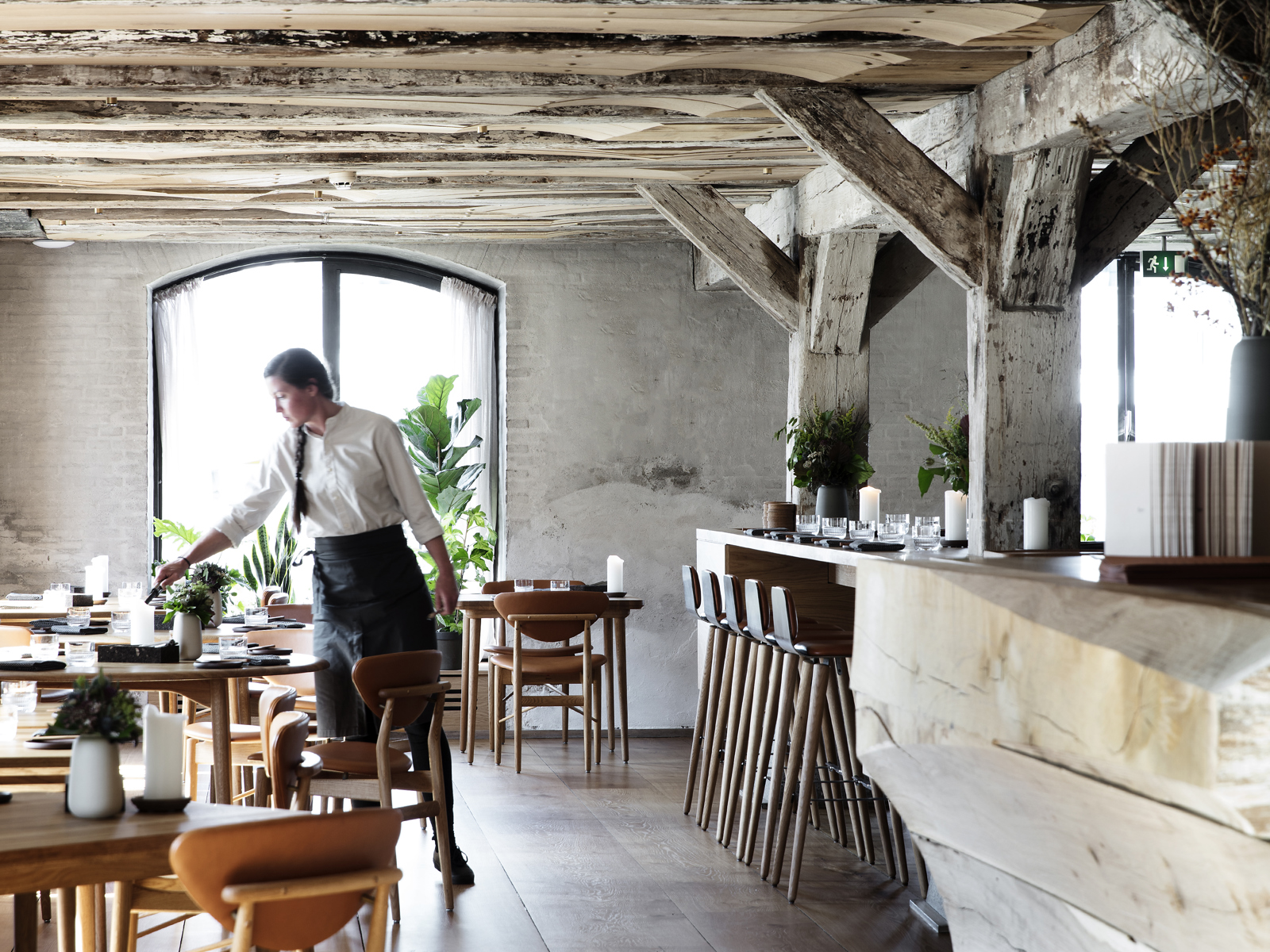 Interiør, restaurant, servitør, eksponert bærekonstruksjon i tre. Foto.