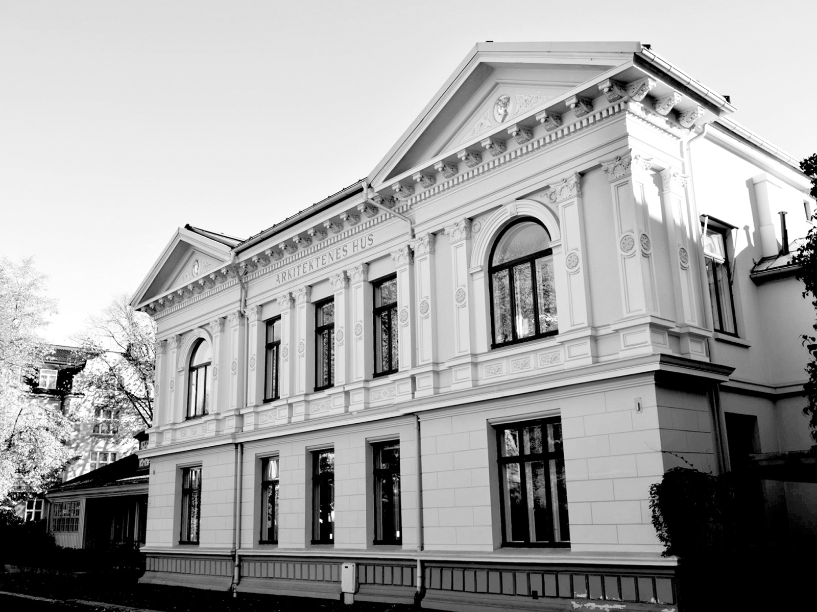 Svart Hvitt bilde av Arkitektenes hus, Hvitt tradisjonelt bygg på to etasjer. Foto.