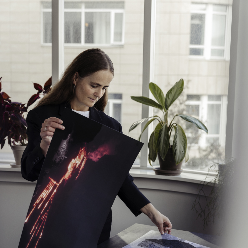 Foto av Arnihildur Pálmadóttir som holder et bilde av lava.