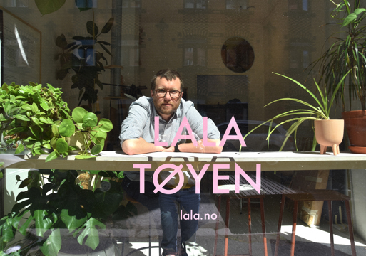 Iwan Thomson sittende på en krakk og ser ut i et vindu. Foto.