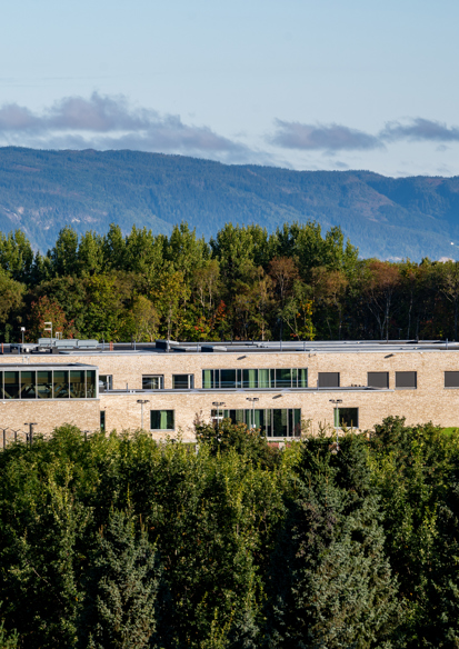 Drone foto av et bygg midt i skogen.