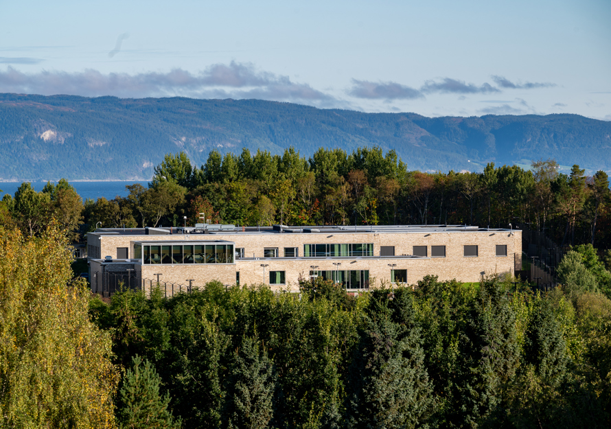 Drone foto av et bygg midt i skogen.