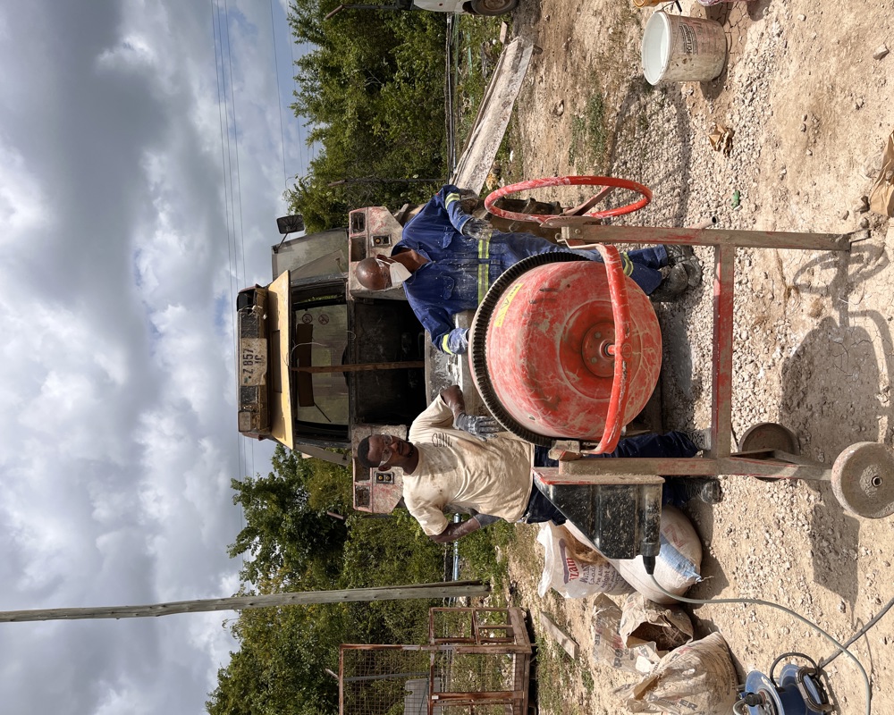 Foto av to menn bak en sementblander. 