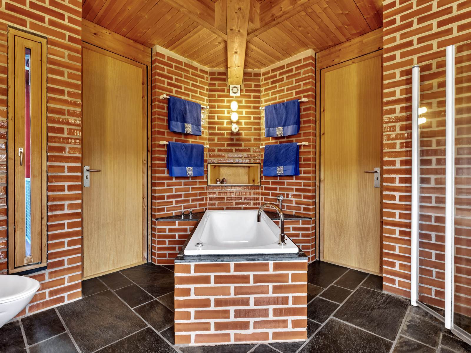 Foto av badet dekket av fliser som ligner murstein.