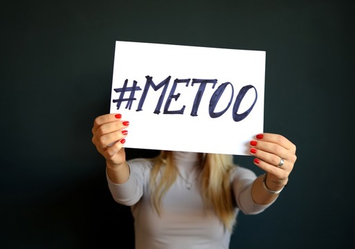 En person som holder en lap med teksten #metoo opp foran ansiktet