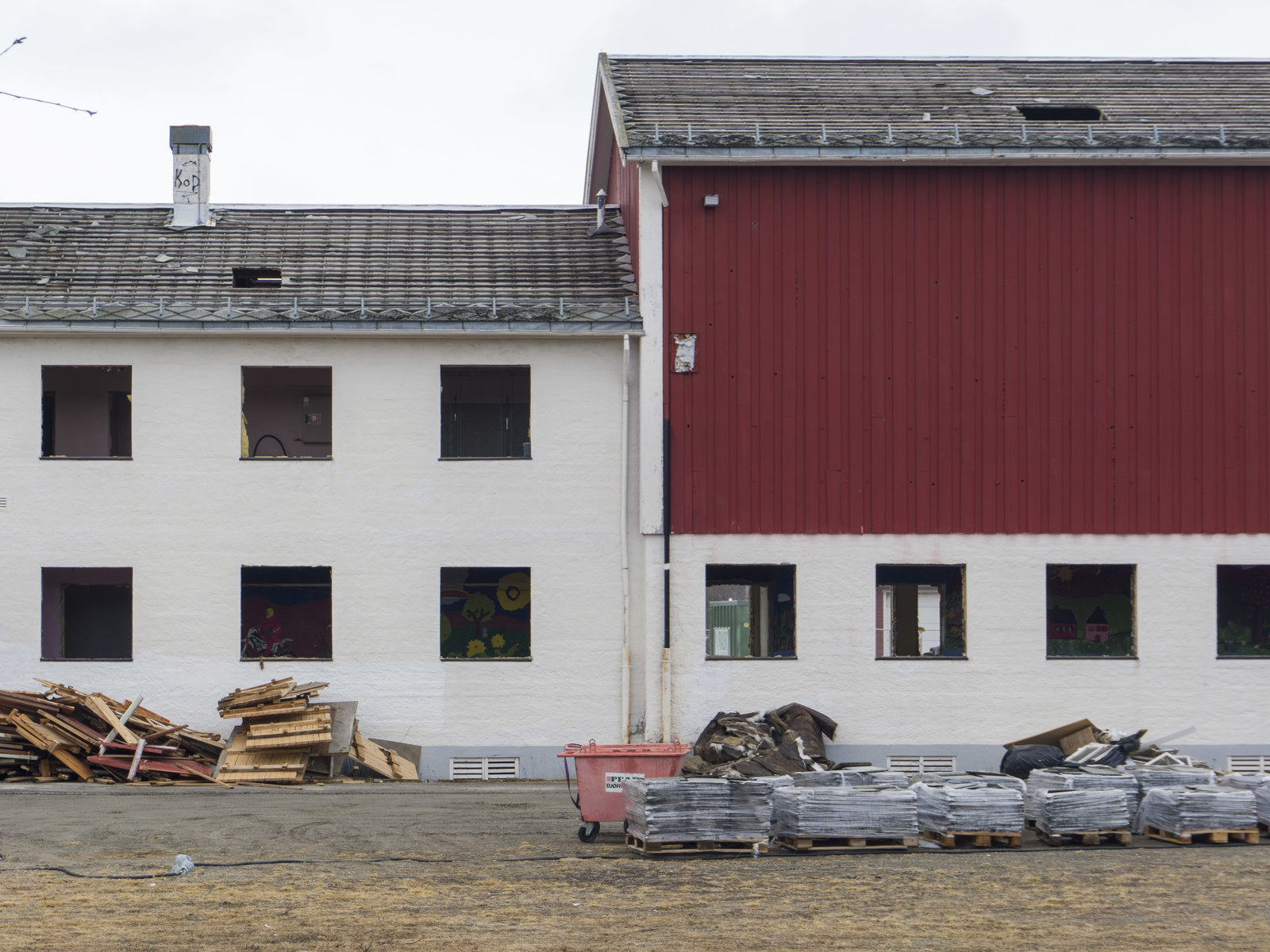 Foto av hvit og rød internatskole uten innsatte vinduer.