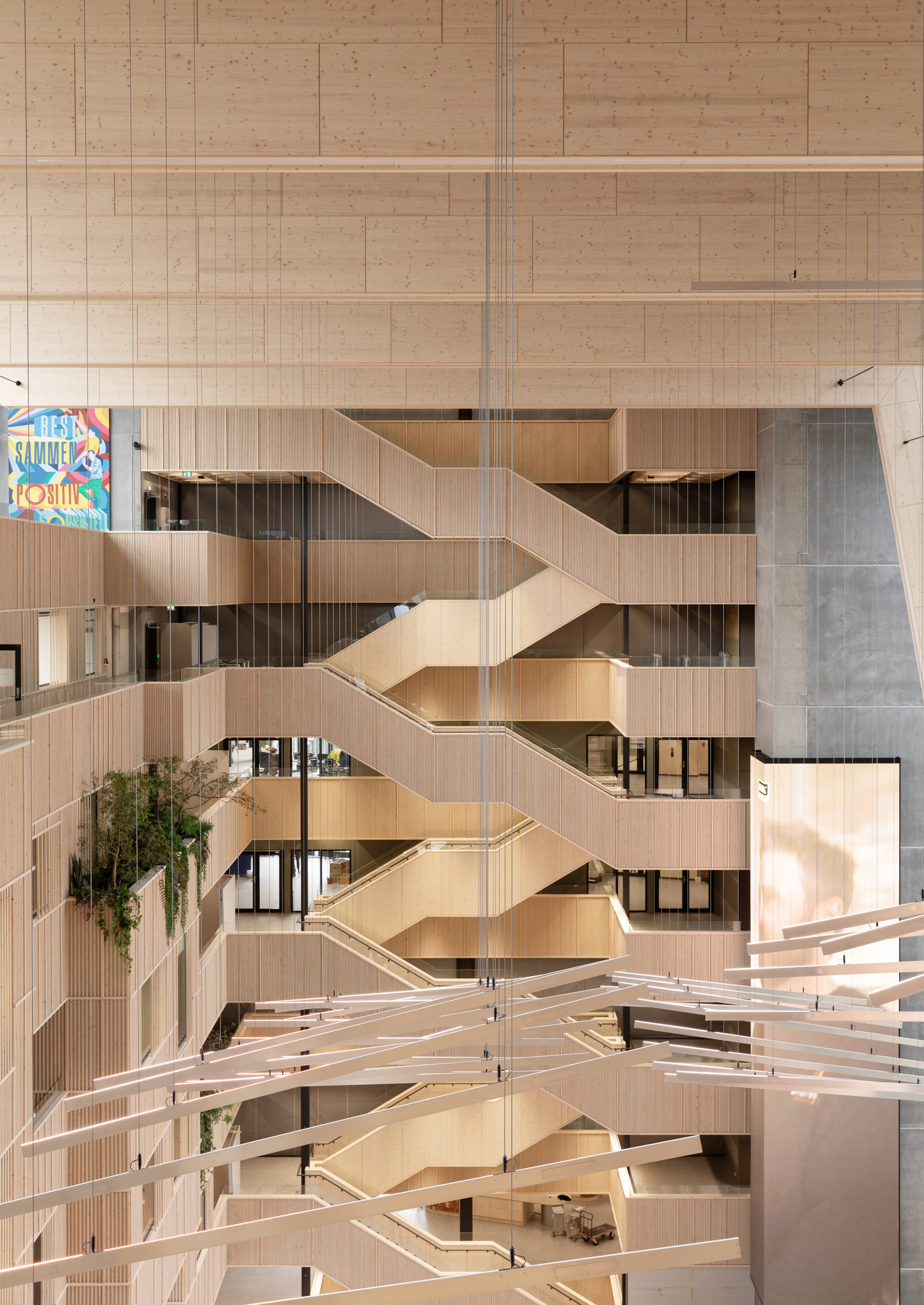 Interiør foto av trapperom og atrium i kontorbygg med limtrekonstruksjon og stor takhøyde.