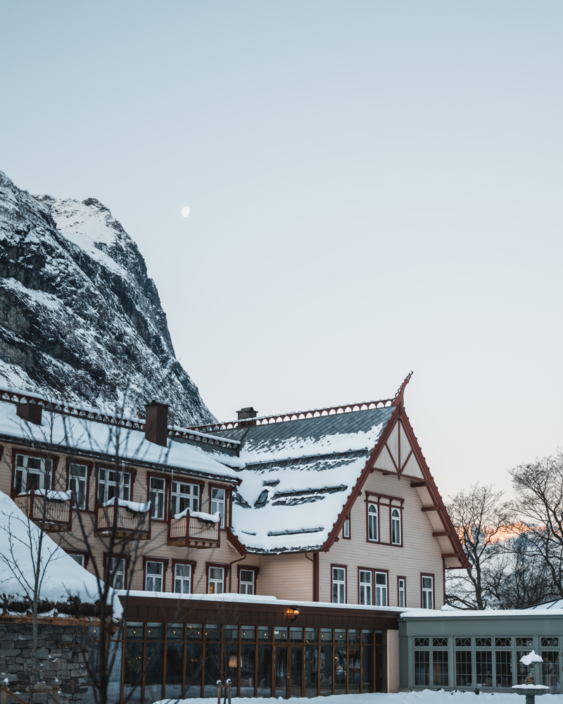 Hotell Union Øye i snølandskap, fjell, himmel og måne i bakgrunnen. Foto.