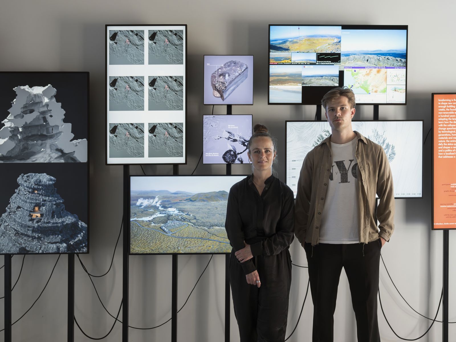 Foto av Arnhildur Pálmadóttir og Arnar Skarphéðinsson fremfor utstilling på skjermer.