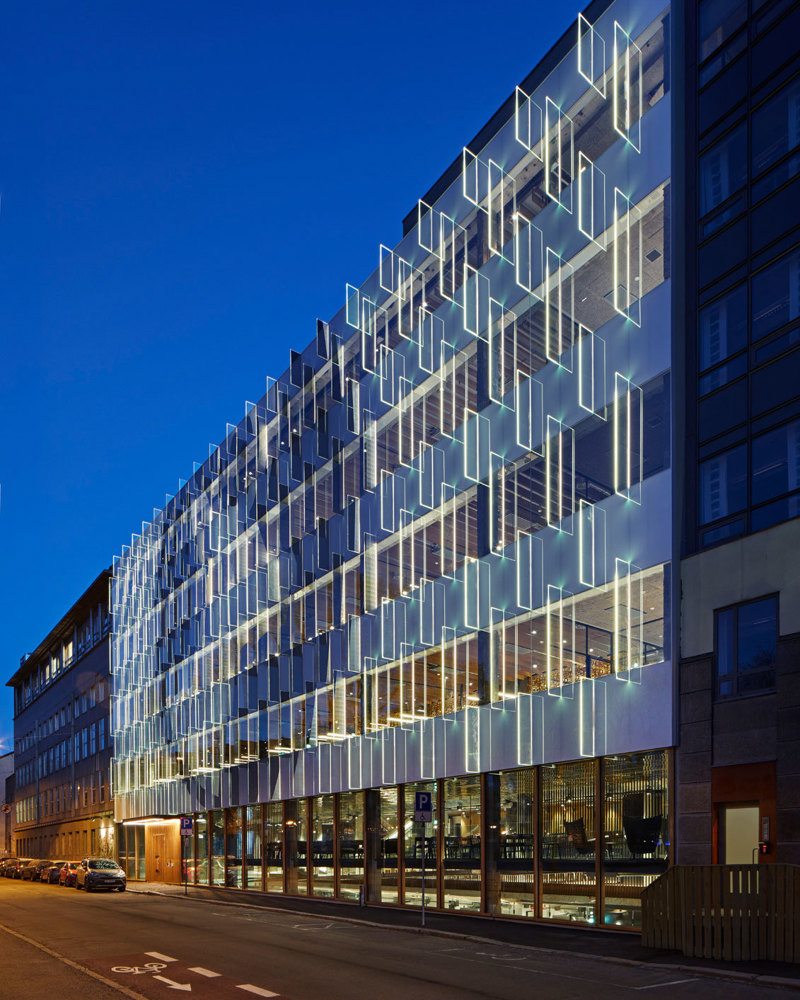 By fotografi i kveldsmørket, bygg med en opplysende fasade.