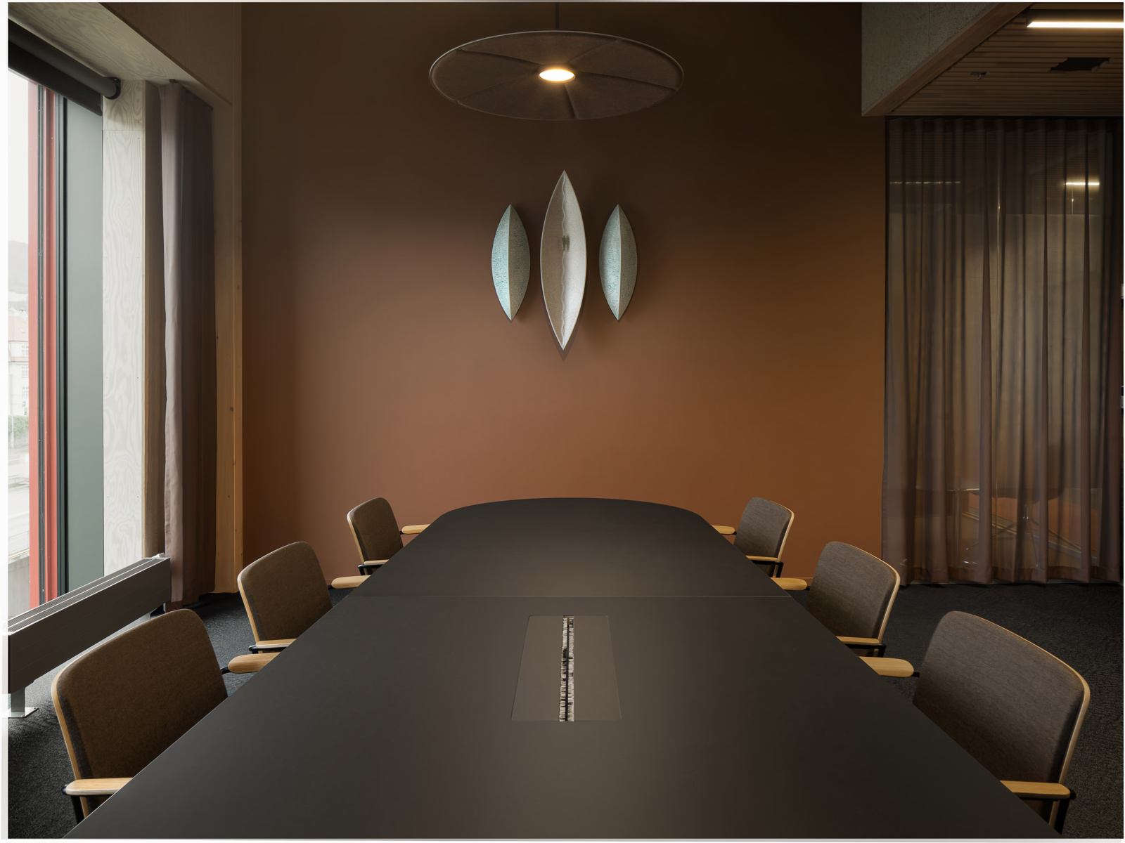 Interiør foto av et møterom med varme mørke farger.