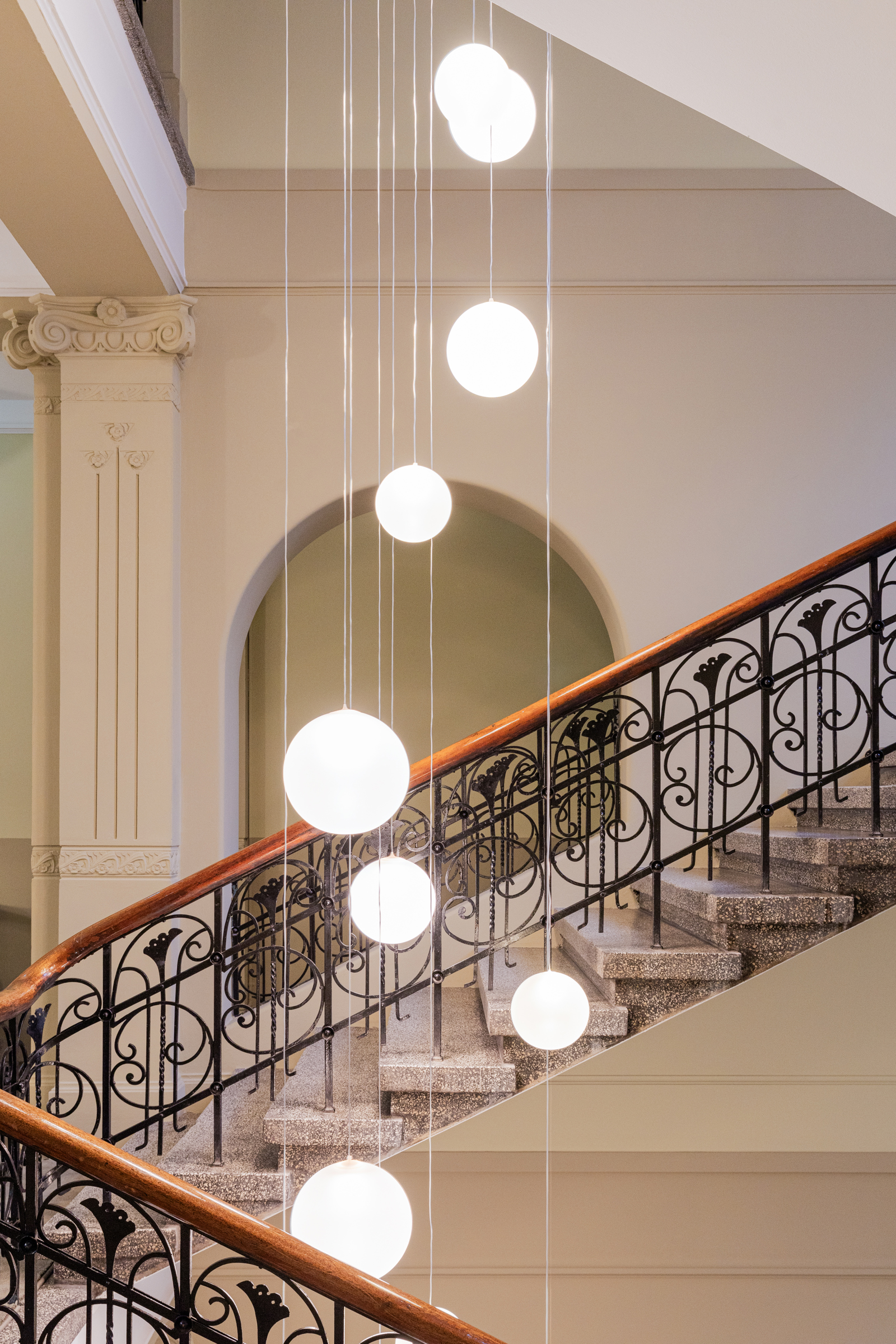 Interiør foto av trappeoppgang med lamper hengende i midten.