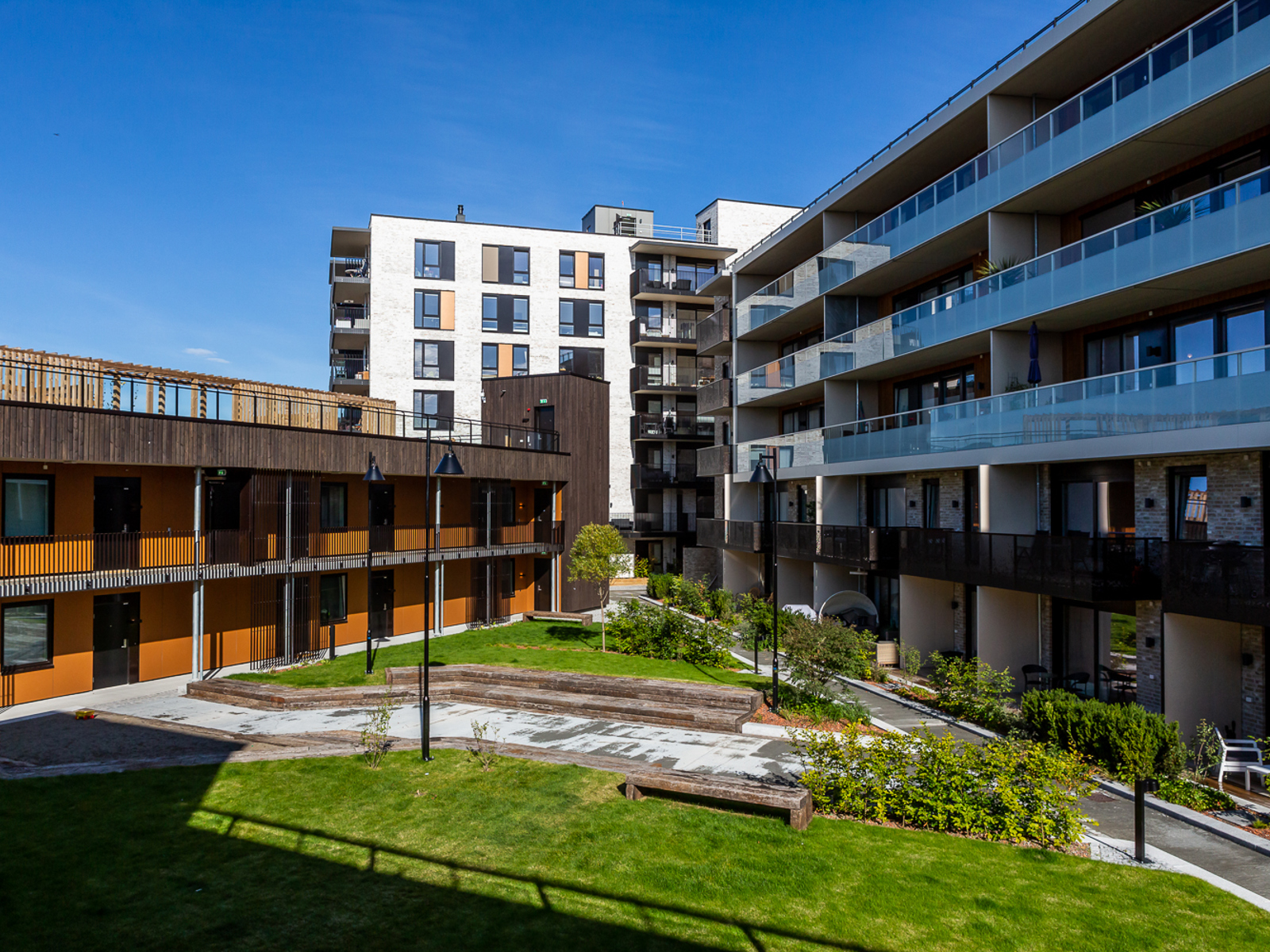 Foto av bakgård mellom leilighetsbygg.