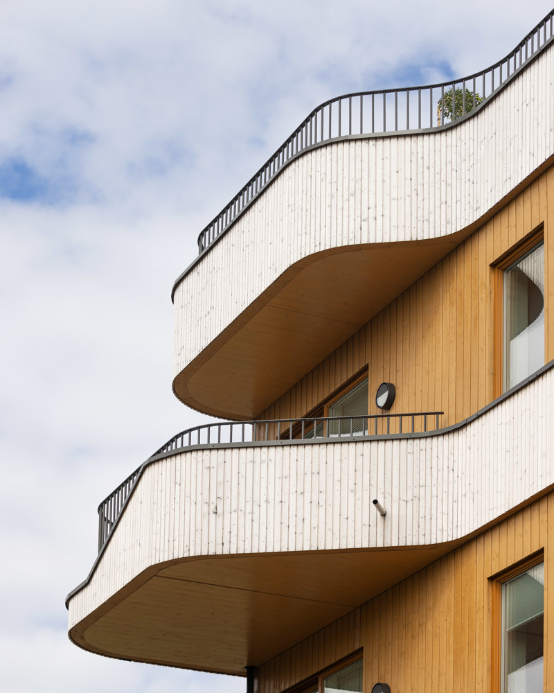 Eksteriør foto av fasade på boligblokk i treverk, avrundet balkong i treverk.