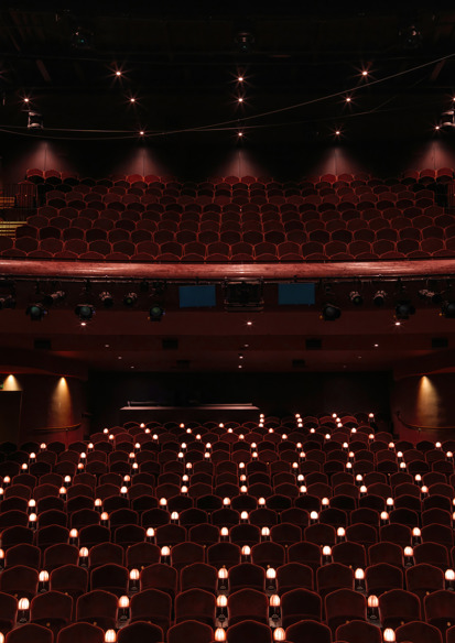 Interiørfoto av publikumssalen i Nye hjorten teater, små lamper ved stolene og to høyder med amfi.