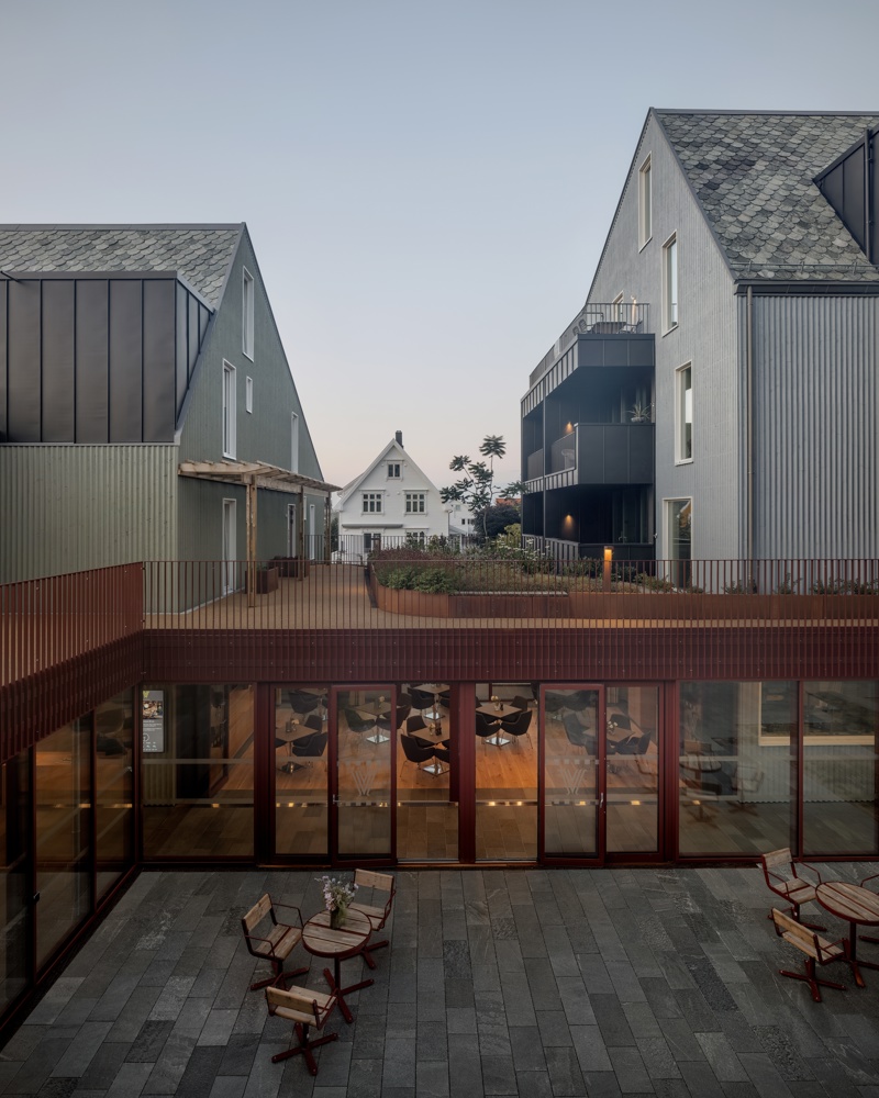 Foto av atrium mellom bygg som fungerer som en lukket hage eller terrasse.