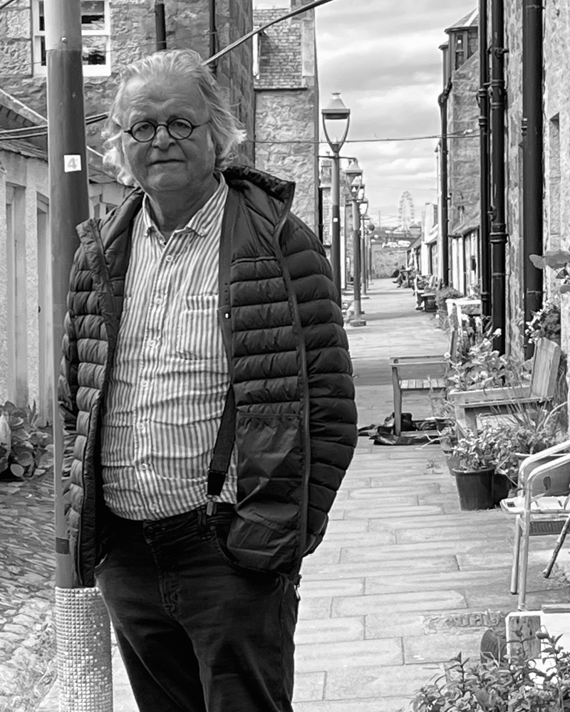 Portrettfoto av Knut Selberg i svart hvitt tatt i et gateløp. 