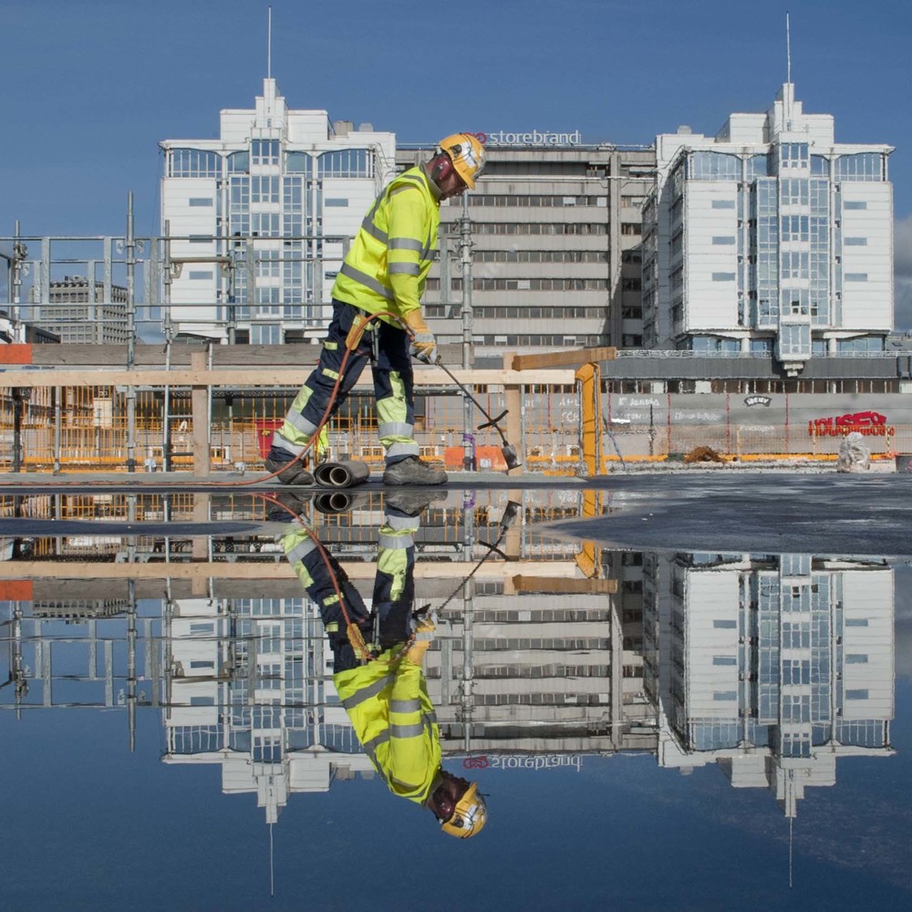 En arbeider på taket av et bygg under konstruksjon