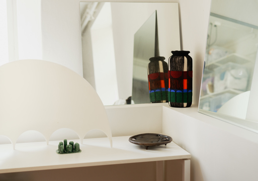 Foto av et hjørne med ulike designgjenstander utstilt.