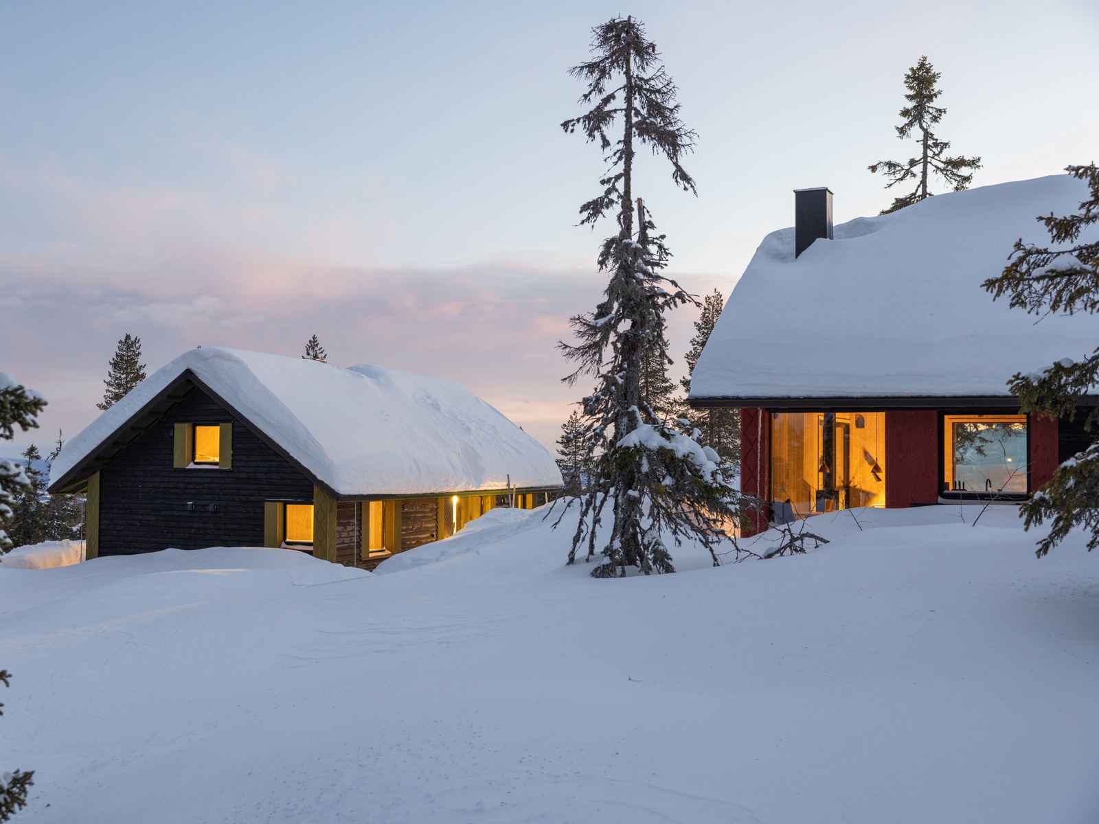 Eksteriør foto av to hytter i snølandskap.