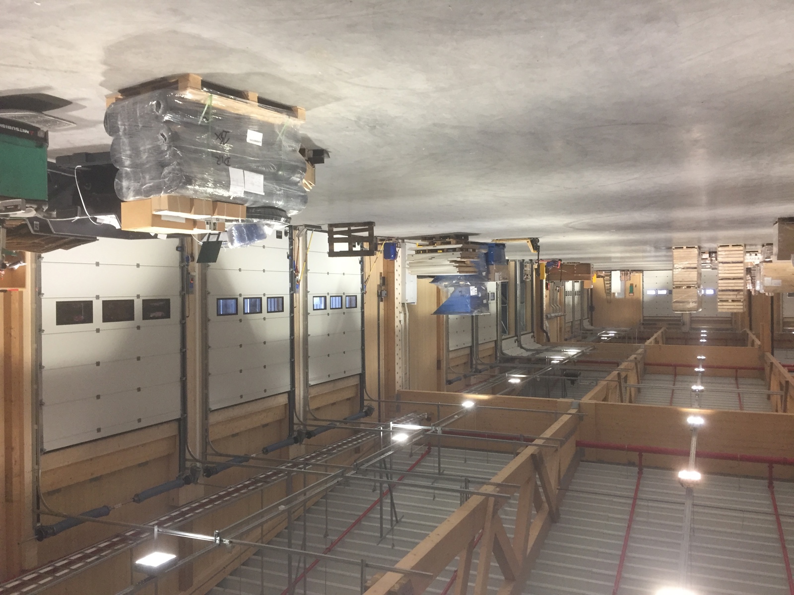 Interiør foto av lagerets betonggulv og massivtre konstruksjon.
