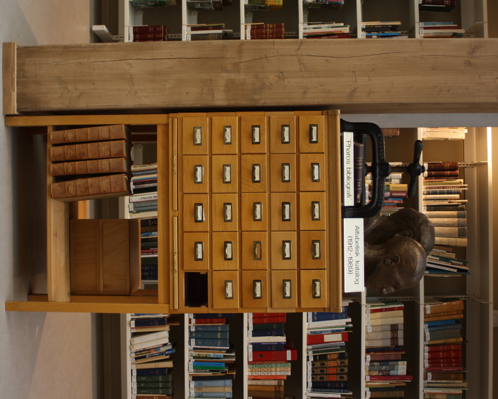 Foto av eldre hylleseksjon i et bibliotek.